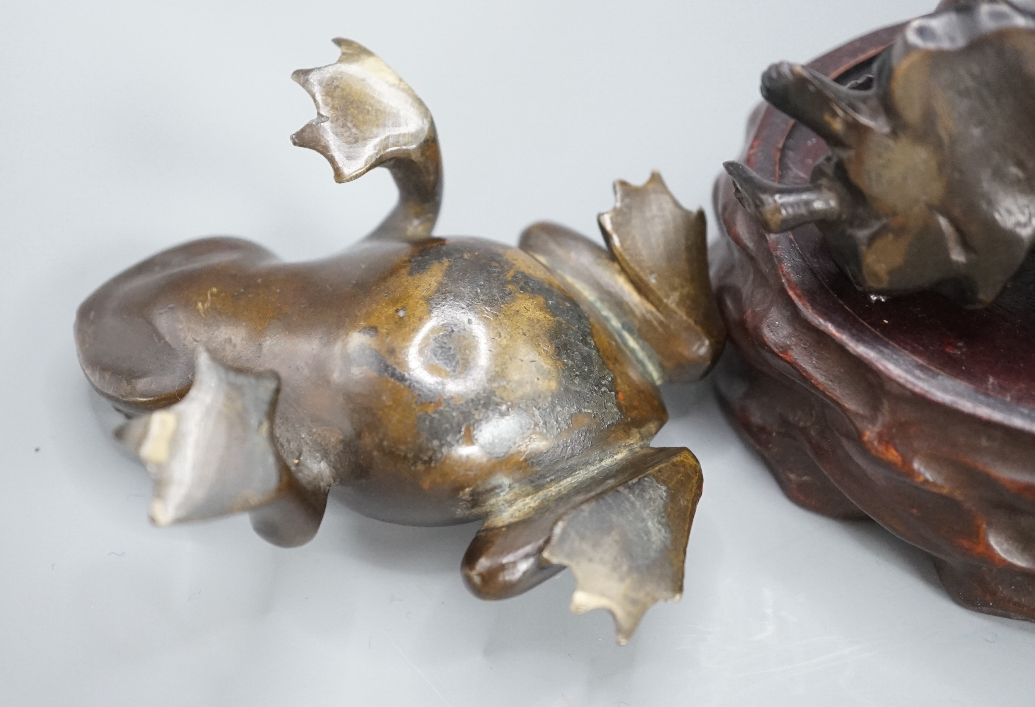 A Chinese bronze group of Liu Hai and a toad, wood stand and a bronze figure of a dog, 9cm